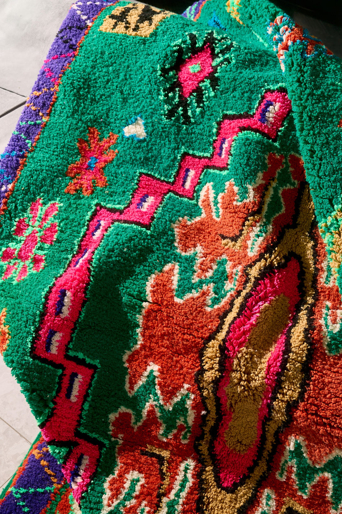 Colorful patterned rug on a plain floor with a neutral wall background