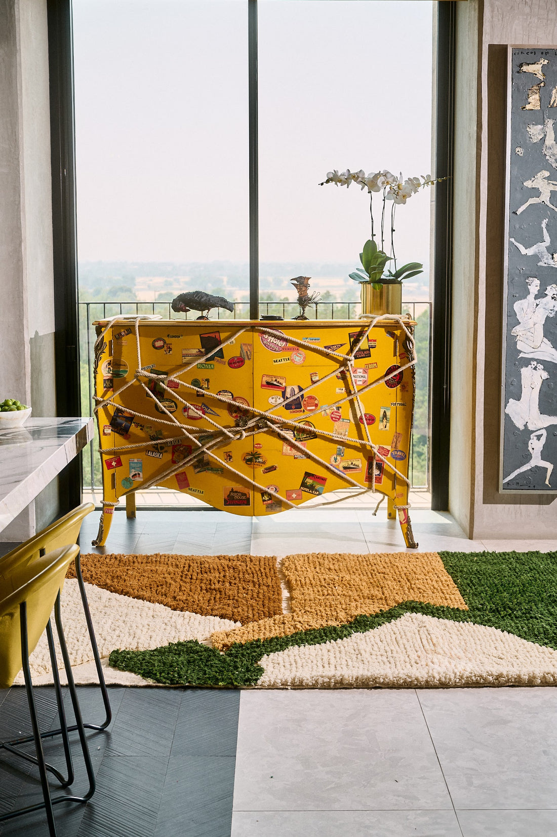 Colorful abstract rug on a gray floor with a modern interior setting.